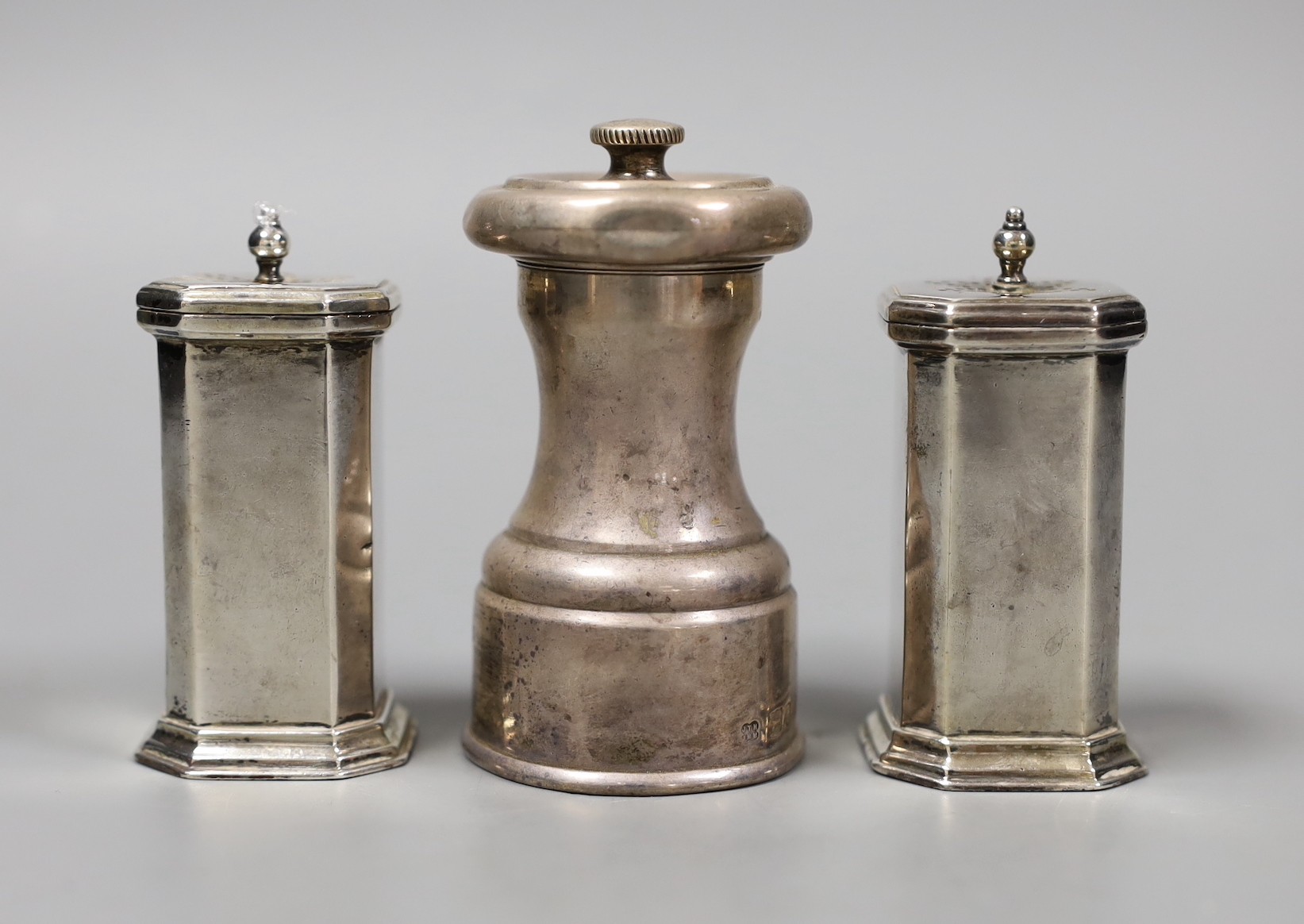 A pair of George V silver pepperettes, Birmingham, 1922, 72mm and a late Victorian silver pepper mill, Hukin & Heath, London, 1896.